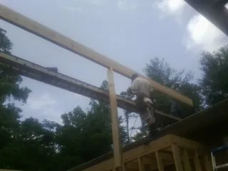 Carpenter setting a ridge beam over a new addition frame — Ice Dam Removal by Roofing Brothers in Admire
